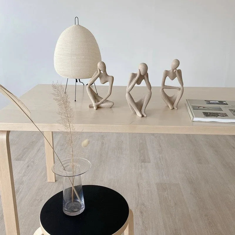 Statuette Le Penseur posée sur une étagère en bois