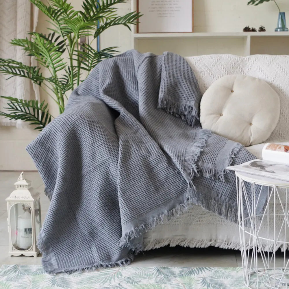 Plaid tricoté gris clair posé sur une chaise