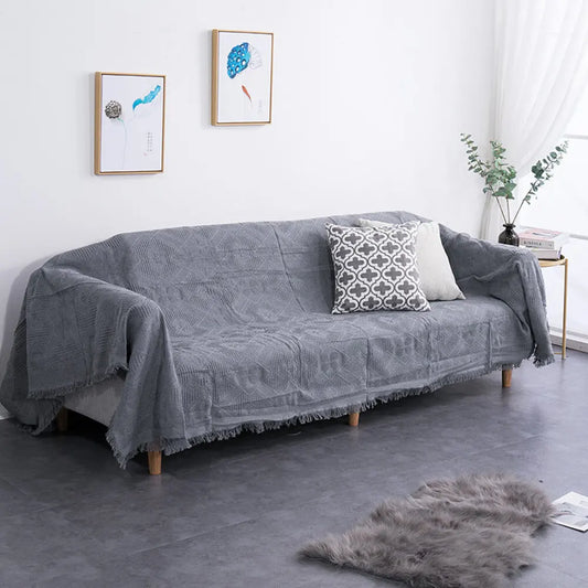 Plaid tricoté en grosse maille beige posé sur un canapé – HAVLY