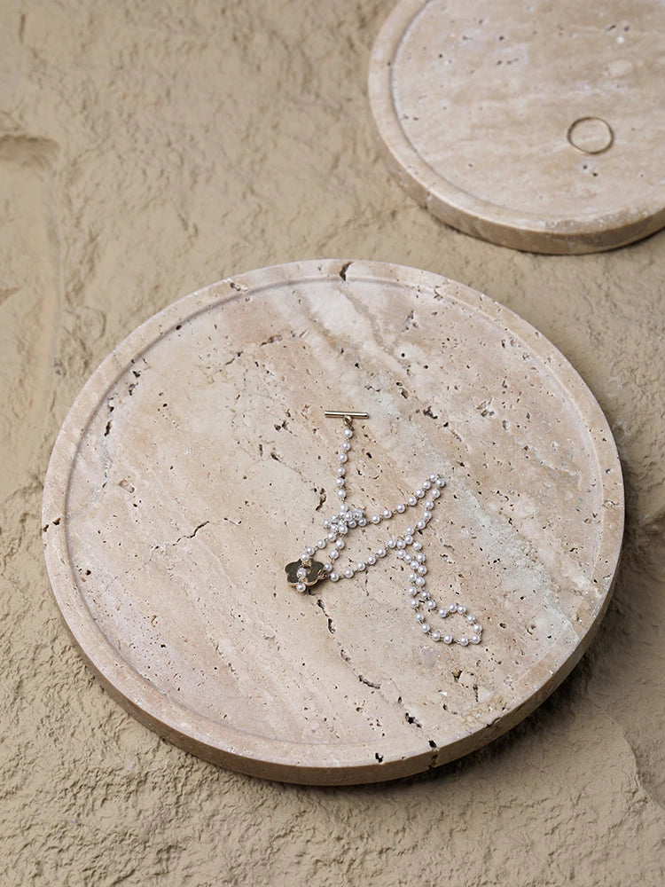 Plateau travertin avec bijoux posés dessus